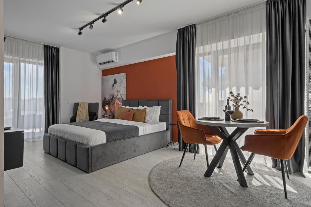een slaapkamer met een bed, een tafel en stoelen bij Terracotta Oasis in Boekarest