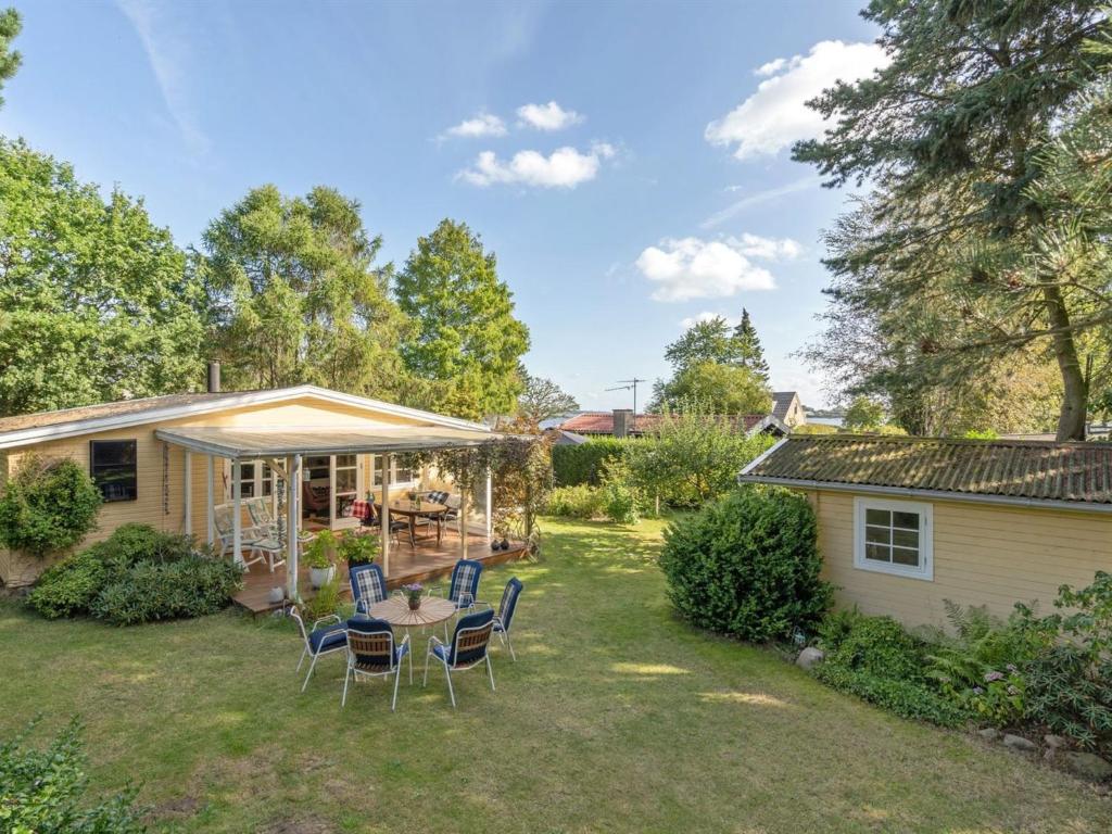 a yard with chairs and a table and a house at Holiday Home Haldis - 120m from the sea by Interhome in Stubbekøbing