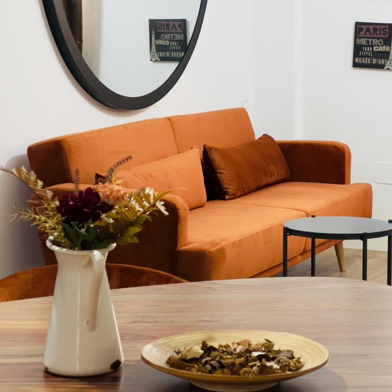 a table with a vase and a plate of nuts on it at Lope 20 - Apartamento céntrico y tranquilo in Jaén
