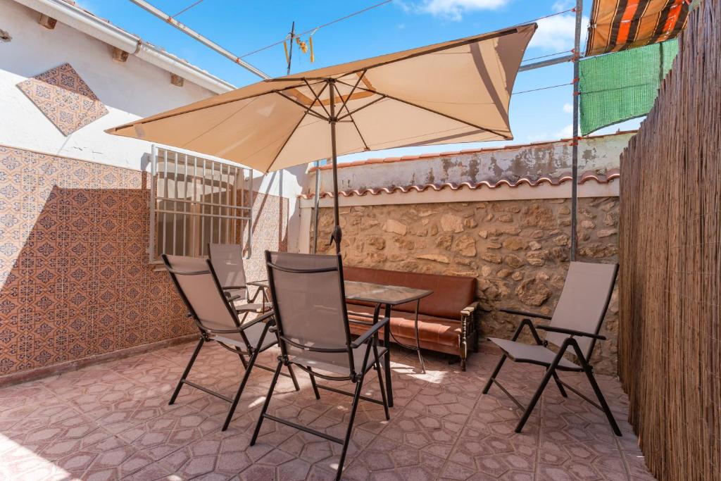 a table with chairs and an umbrella on a patio at Antique Spanish Villa With A Patio in Guardamar del Segura