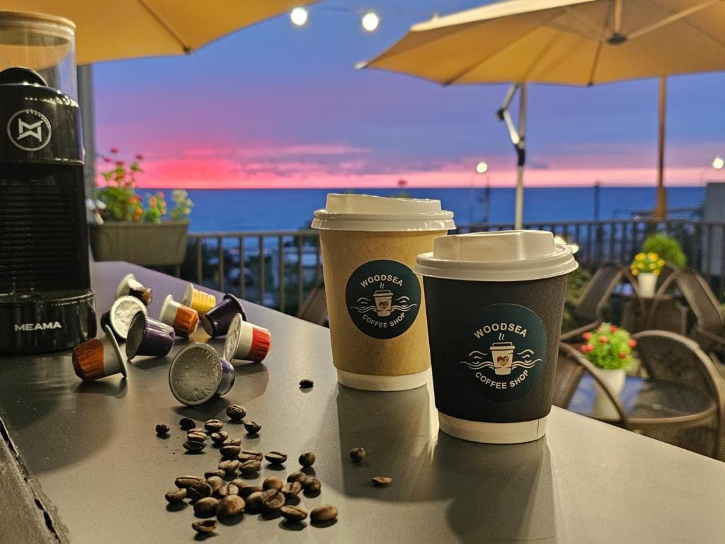 two cups of coffee sitting on a table with coffee beans at WoodSea in Batumi