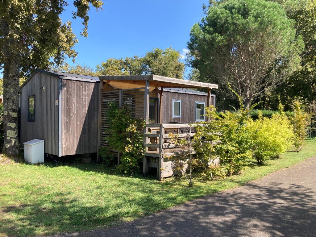 a tiny house sitting on the grass in a yard at Mobil Home 6 personnes in Biscarrosse