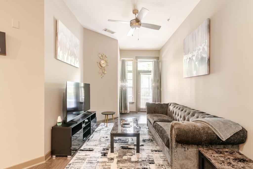a living room with a couch and a tv at Stylish 1BR Uptown Apartment in Charlotte