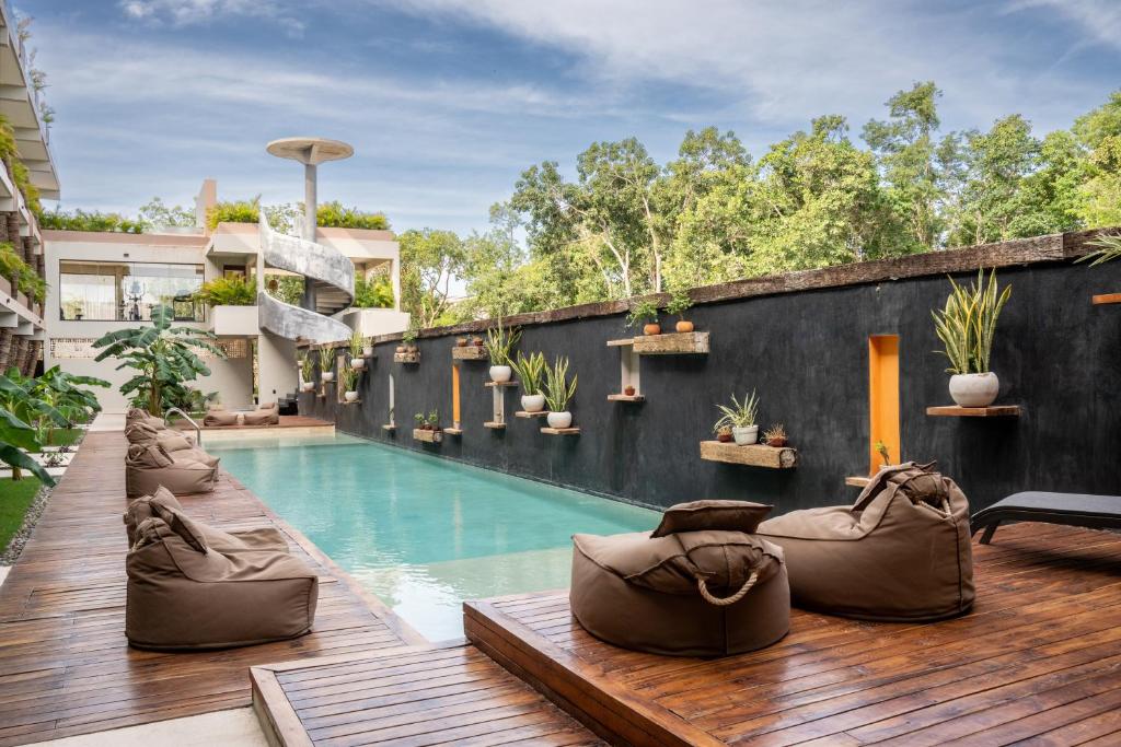 a backyard with a swimming pool and a wooden deck at TULUM XAMIRA PRIVATE SPA Balcony in Tulum