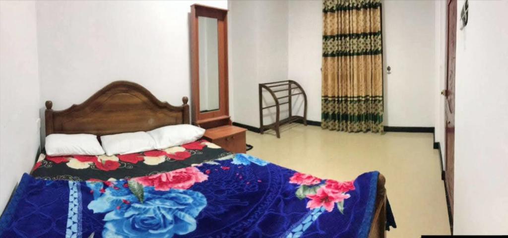 a bedroom with a bed with a blue comforter at Midnight Oasis in Nuwara Eliya