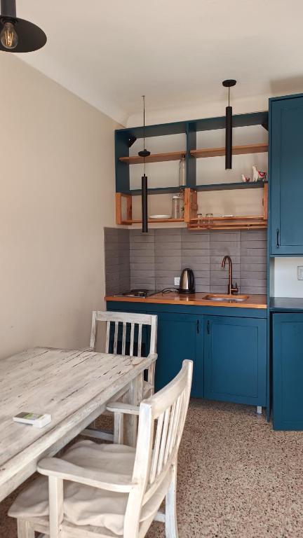cocina con mesa de madera y armarios azules en Cirilos, en Dolores