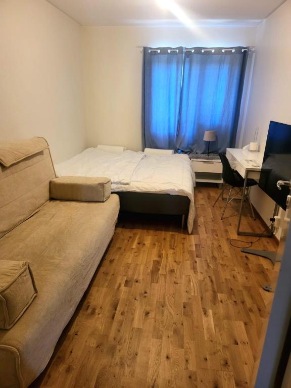 a bedroom with a bed and a couch and a desk at Comfort Us 2 - Cozy Private Home in Uppsala