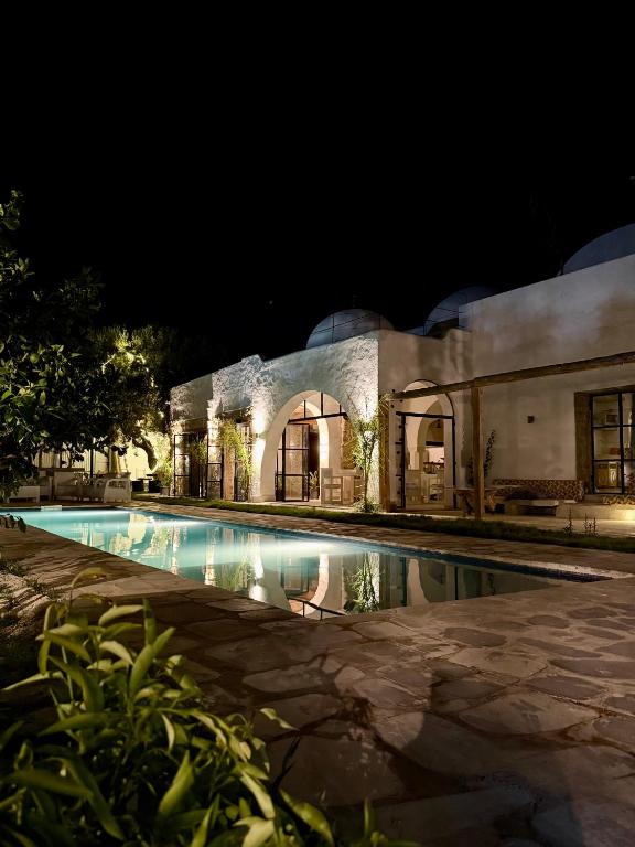 a house with a swimming pool at night at Casa Dea - Bungalow Aphrodite in Hammamet Sud