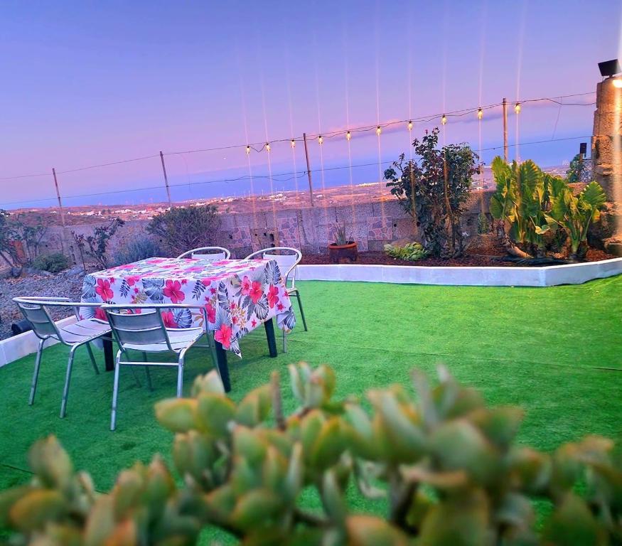 a table and chairs on a lawn with a view at relaxing country house with wonderful ocean view in Granadilla de Abona