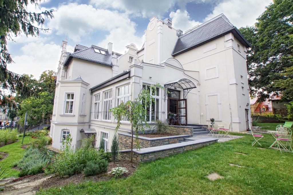 an exterior view of a white house with a yard at Versant Hotel & Spa in Dzierżoniów