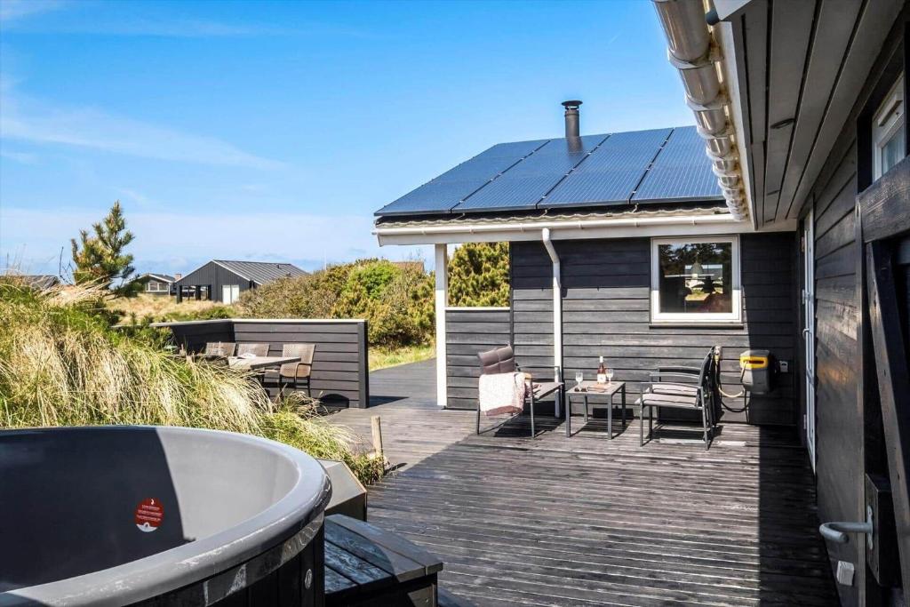 een huis met een houten terras met een badkuip bij JB230-Frostrup-Grabakkevej-4 in Lild Strand
