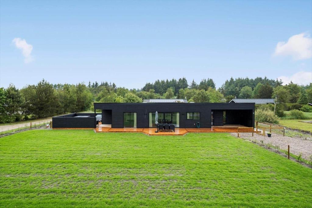 una casa nera con un grande cortile verde di JB350-Fjerritslev-Egevej-9 a Fjerritslev