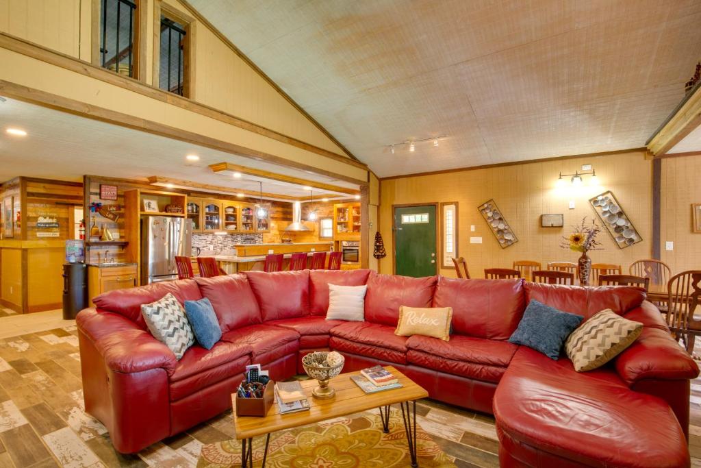 a living room with a red couch and a table at Bayview - Lakefront Family Cabin in Odessa! in Odessa