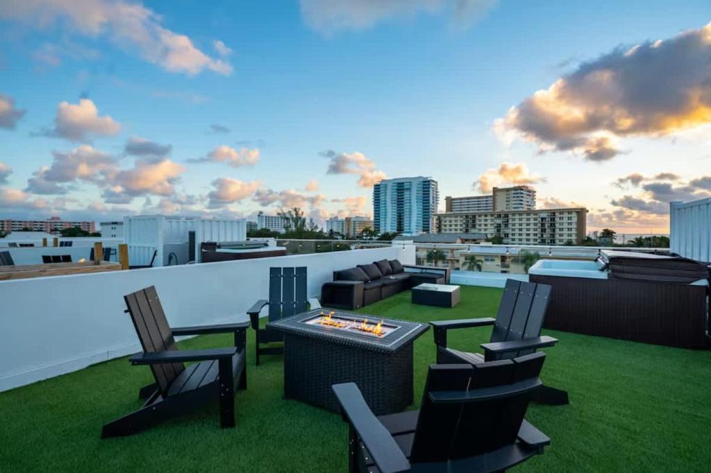 Un patio con sillas y una mesa en un tejado. en New Construction Villa 2 min Walk to Beach Jacuzzi, en Pompano Beach