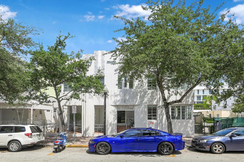 un coche azul estacionado frente a un edificio blanco en St Augustine Hotel, en Miami Beach
