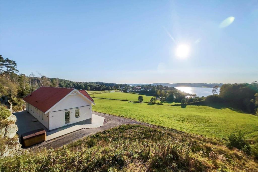a small white house on a hill next to a field at BOH607-Udevalla-Kolvik-254 in Klev