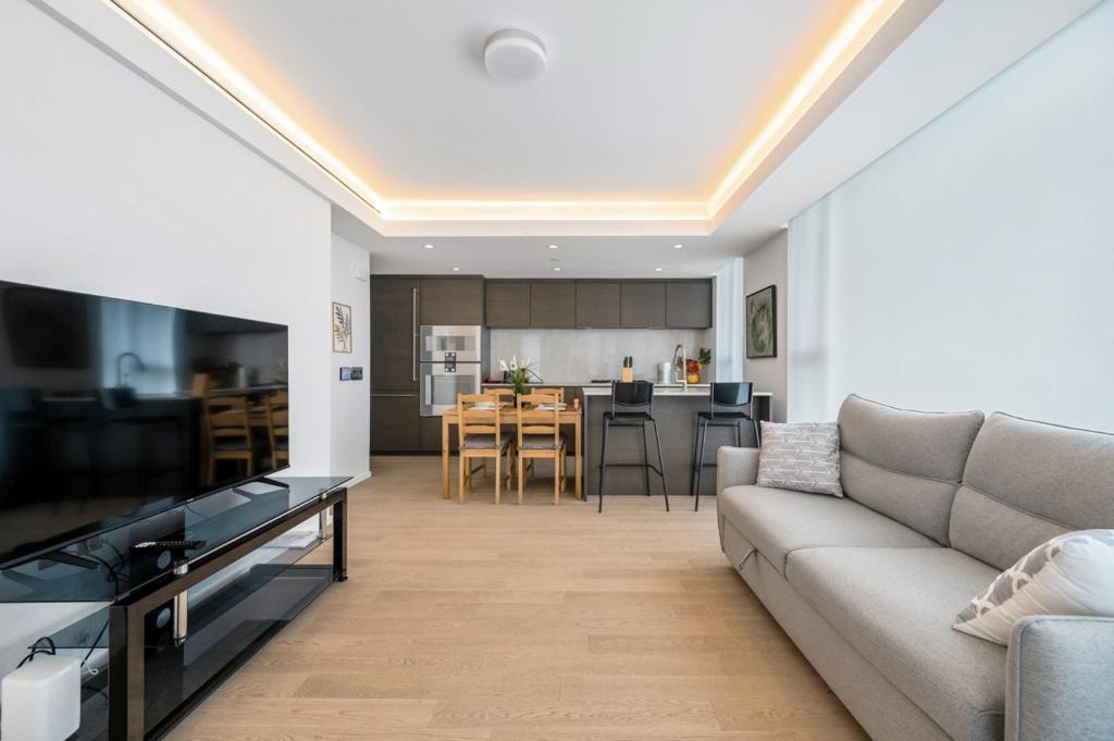 a living room with a couch and a kitchen at Urban Retreat 2BR Condo with Stunning City View in Vancouver