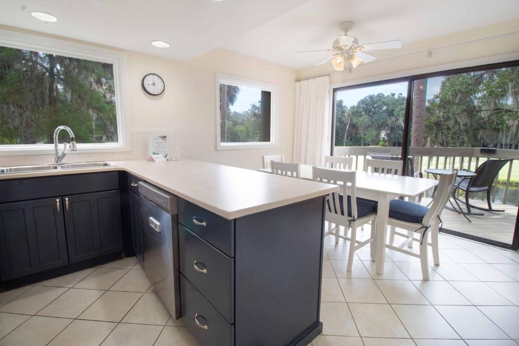 a kitchen with a sink and a table with chairs at 611 Magnolia-Stella Maris in Edisto Island