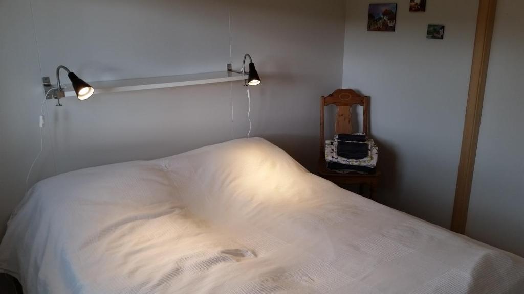 1 dormitorio con cama blanca y espejo en Birkikinn Holiday Home, en Birkikinn