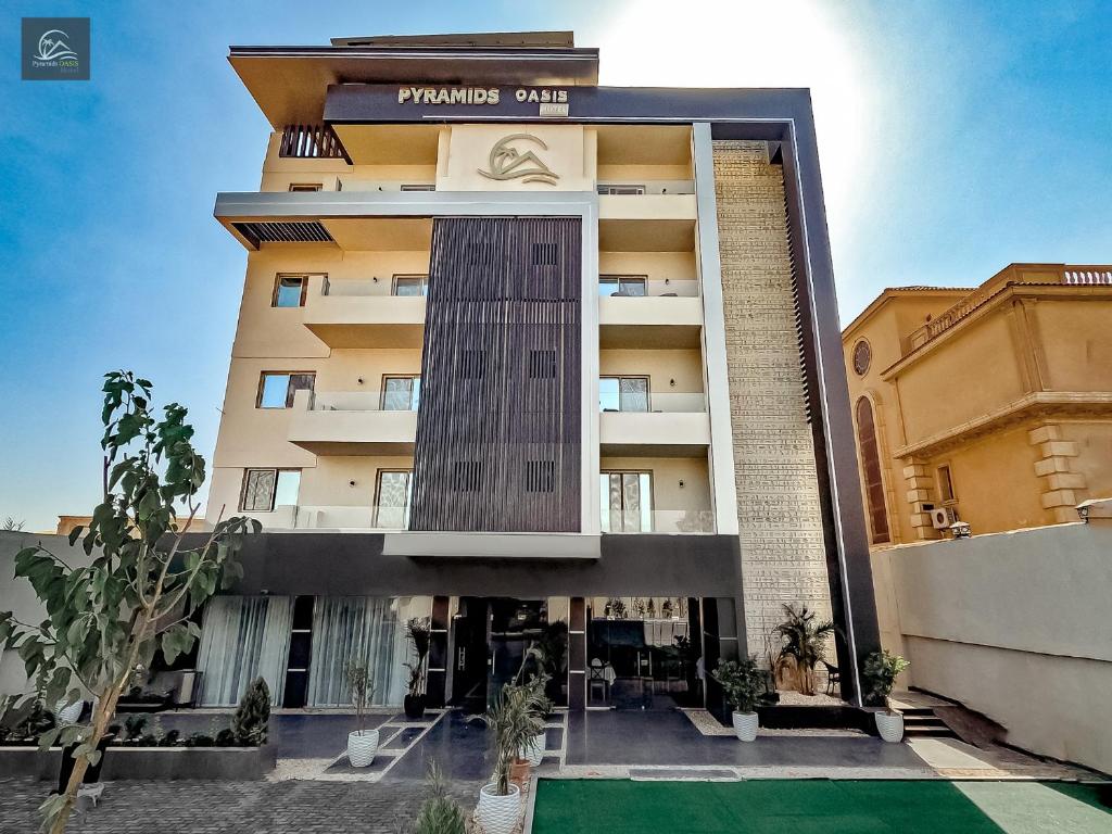 a tall building with a courtyard in front of it at Pyramids Oasis Hotel - Giza in Cairo