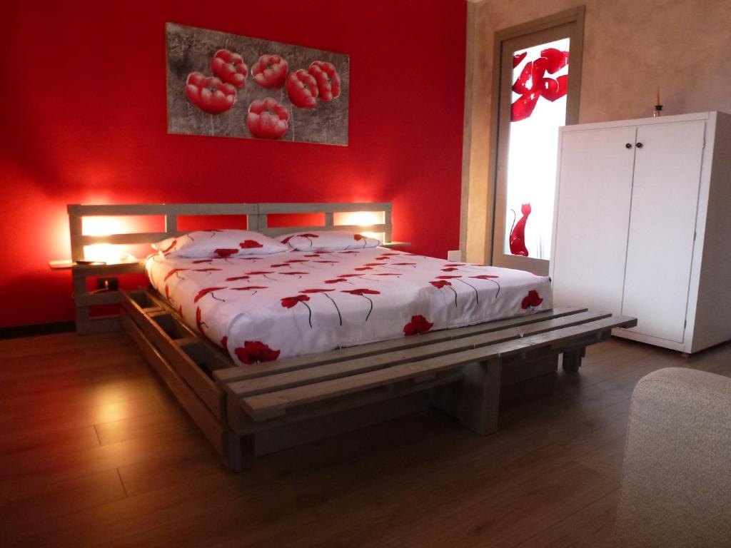 ein Schlafzimmer mit einem Bett mit einer roten Wand in der Unterkunft La Cà ët Mec in Robilante