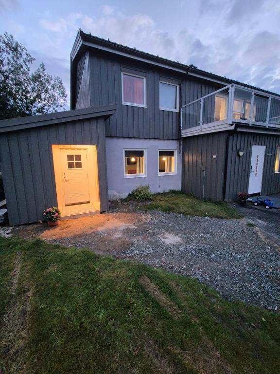 a house with a yellow door and a garage at Overnatting Kjøllefjord, Hybelleilighet med kjøkkenkrok og eget bad in Kjøllefjord