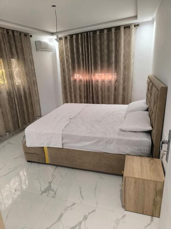 a bedroom with a bed and a window with curtains at Appartement nador G in Nador