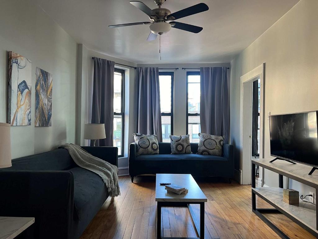 Una sala de estar con un sofá azul y un televisor. en South Loop 3 Bedroom Apt, en Chicago