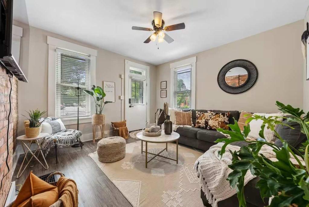 een woonkamer met een bank en een plafondventilator bij Sophisticated Boho Condo Walkable Columbus in Columbus