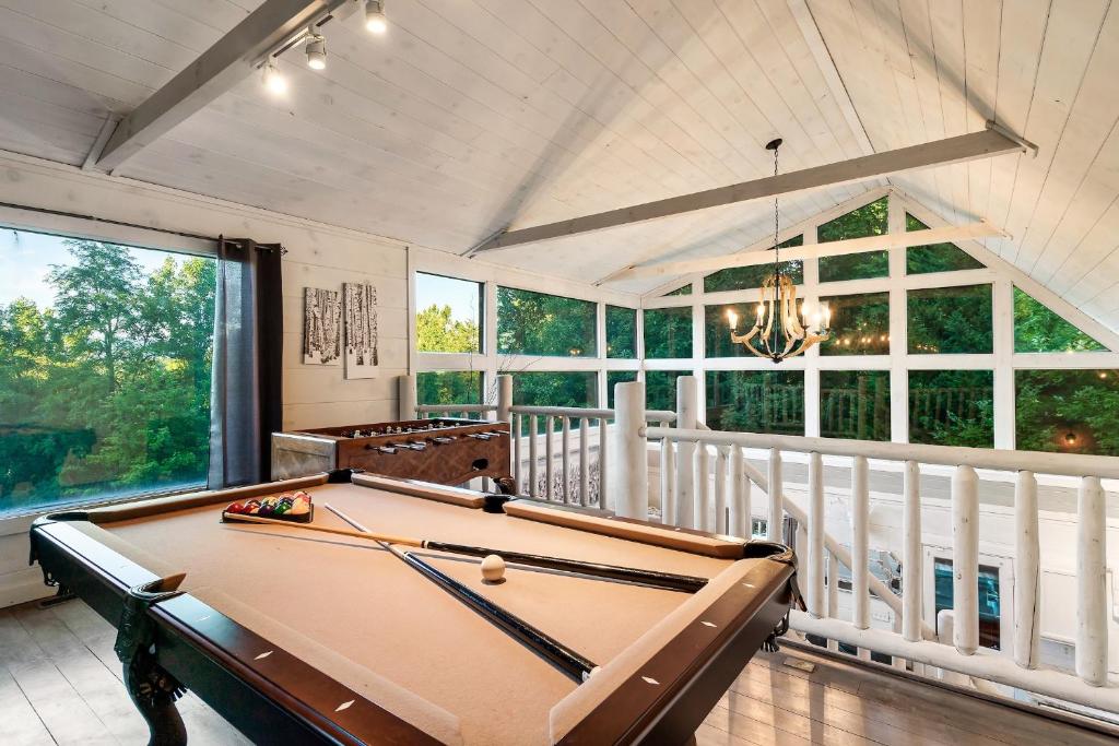 einen Billardtisch in einem Zimmer mit Fenstern in der Unterkunft Smokies Getaway Special! Hot Tub, Games, Views & just 4 miles to Pigeon Forge! in McCookville