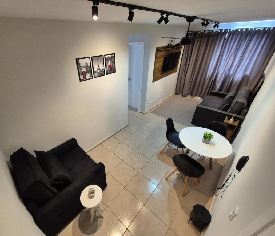 a living room with black furniture and a white table at Apartamento de 1 quarto !! in Joinville