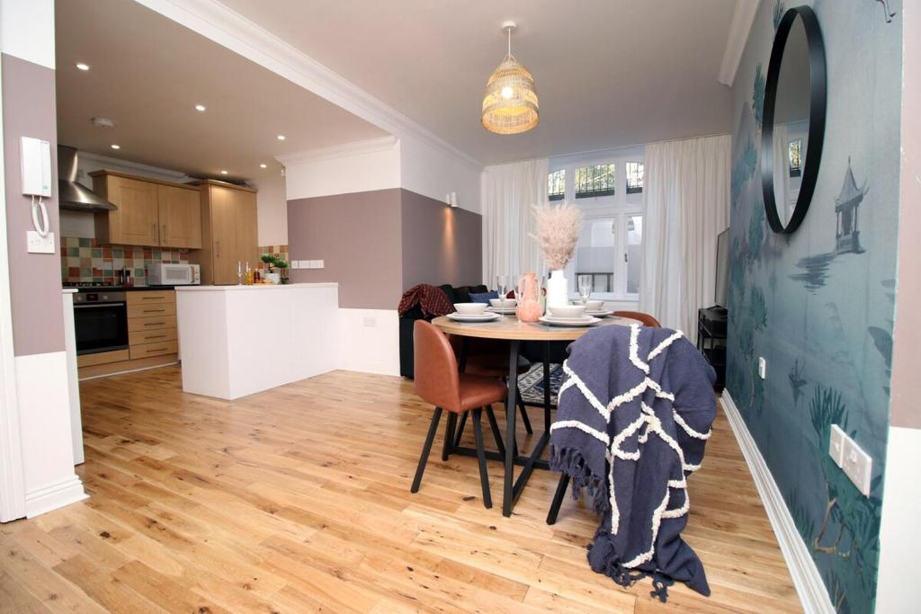 eine Küche und ein Esszimmer mit Tisch und Stühlen in der Unterkunft BURLINGTON LUXURY APARTMENT- SLEEPS 6- SUPER FAST WiFi- PRIVATE PARKING SPACE- FLAT SCREEN SMART TV- FREE ONSITE GYM- 1 MIN DRIVE TO BOSCOMBE PIER- GREAT LOCATION! in Bournemouth