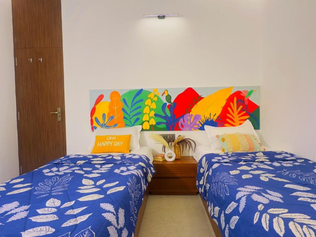 a bedroom with two beds and a painting on the wall at Soul Club - 1hr from HSR, Outdoor Cinema, Pool, Meditation Room, BBQ in Hosūr
