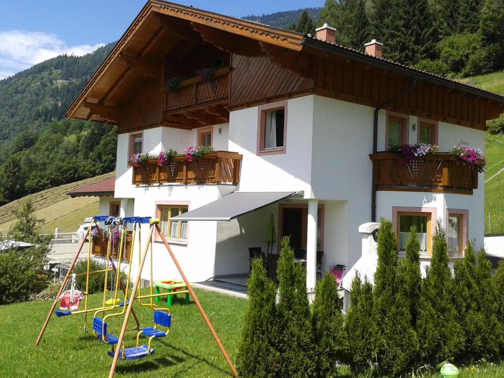 ein Haus mit einem Spielplatz davor in der Unterkunft Landhaus Sarah in Dorfgastein