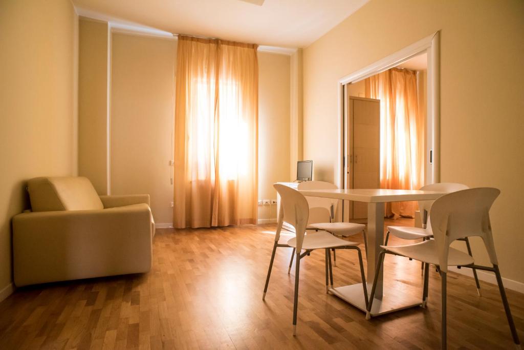 sala de estar con mesa, sillas y sofá en Dante Ravenna Apartments, en Rávena