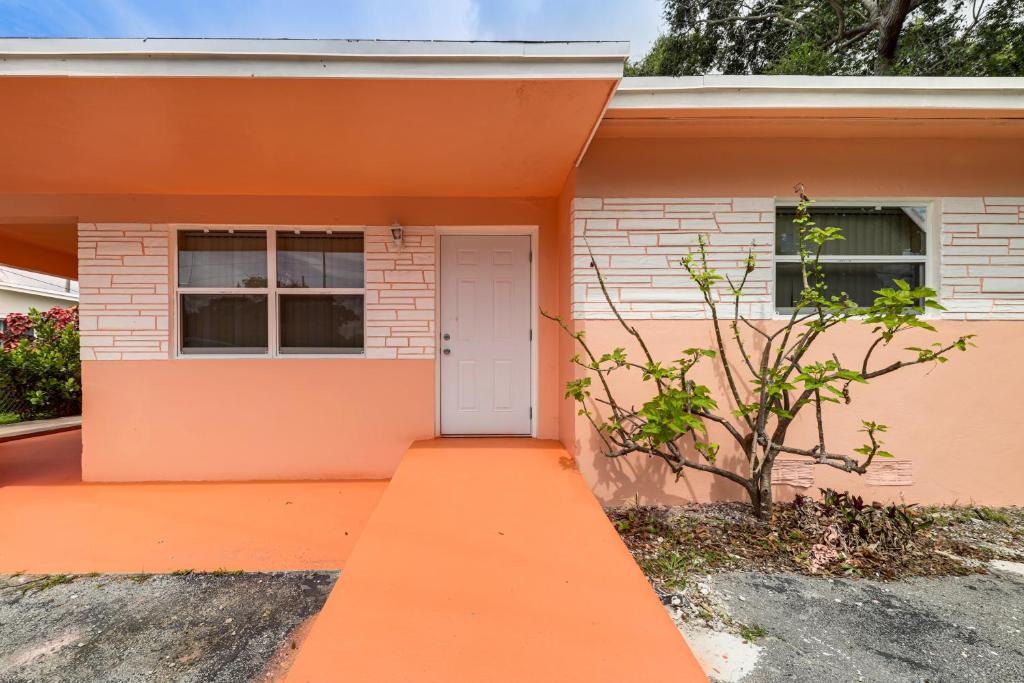 デイニア・ビーチにある3 Mi to Dania Beach Pier Convenient Apartment!の白いドアの付いたオレンジ色の家