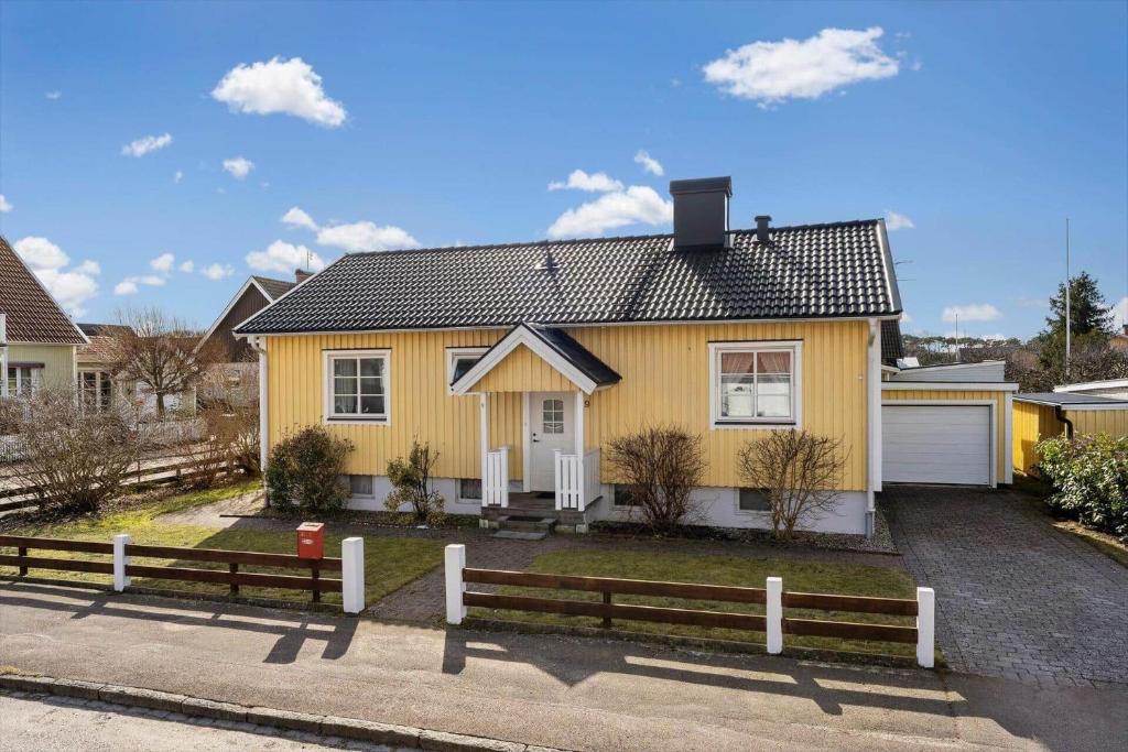 una casa gialla con una recinzione davanti di HAL599-Falkenberg-Villavaegen-9 a Anderstorp