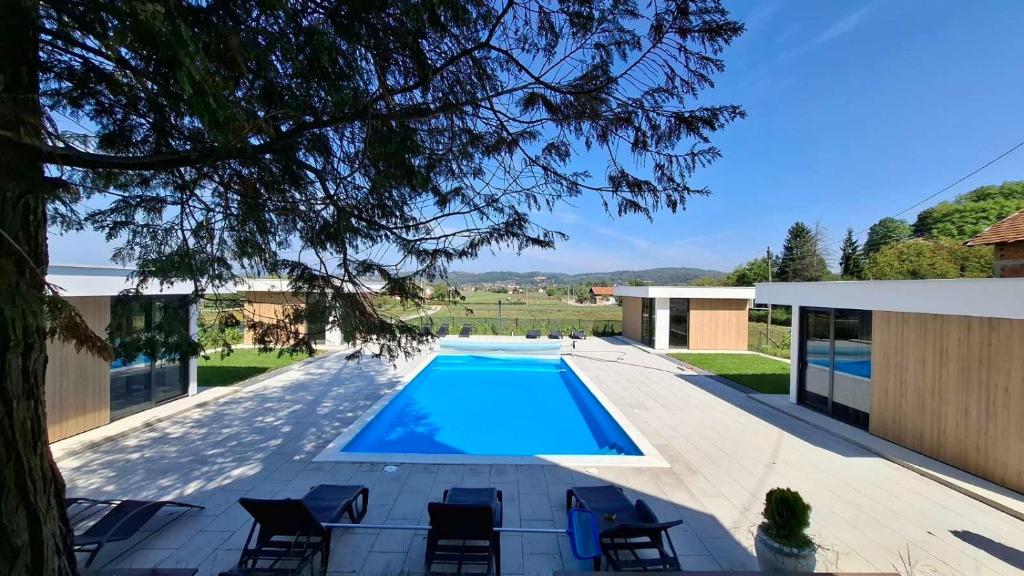 a swimming pool with chairs next to a building at Elysium1 in Banja Luka