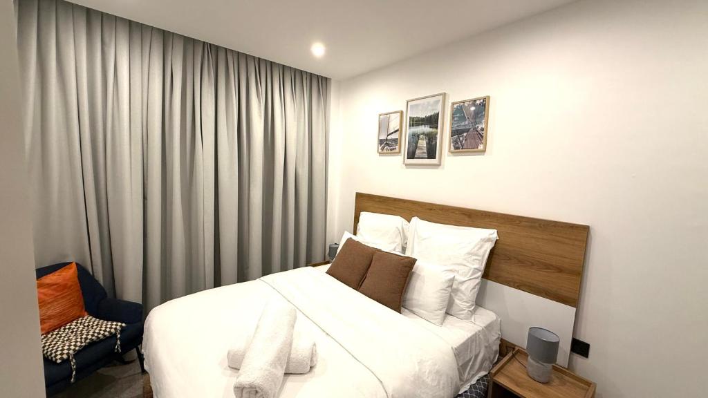 una camera da letto con un letto con lenzuola e cuscini bianchi di Stylish 1-Bedroom with Stunning City View atNova with PS-5 a Accra