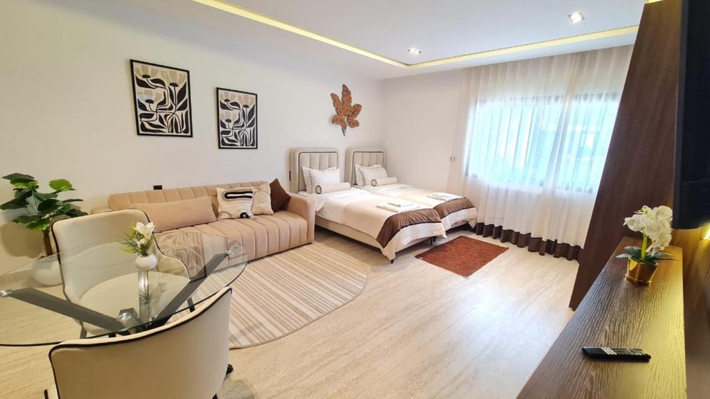 a living room with a couch and a bed at Douceur Neroli à Ain zaghouen Nord in Sidi Daoud