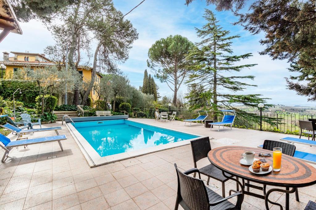 a patio with a table and a swimming pool at Villa Paola Private Pool Gym in Chianti - Happy Rentals in Montespertoli