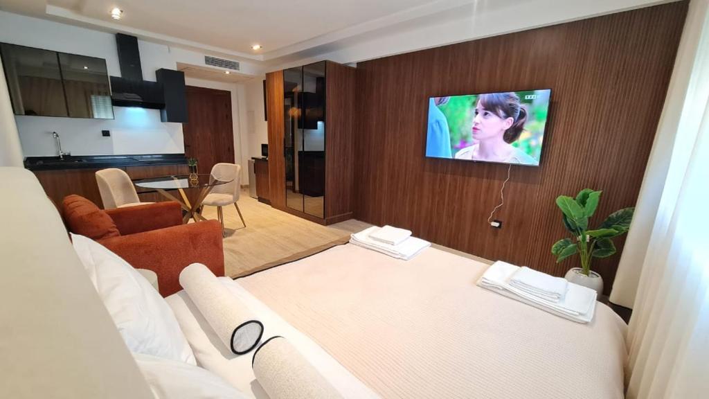 a living room with a couch and a tv on a wall at Douceur oranger à Ain Zaghouen Nord in Sidi Daoud