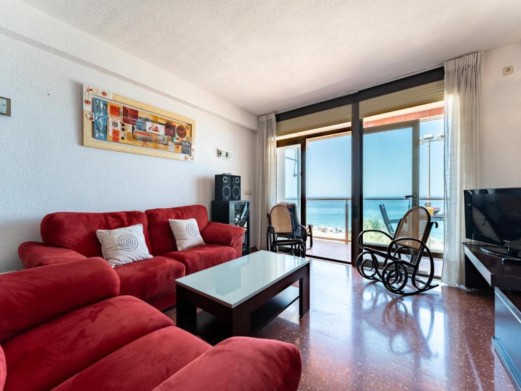 sala de estar con sofá rojo y TV en Faro's Zapillo Apartment - Almeria, en Almería