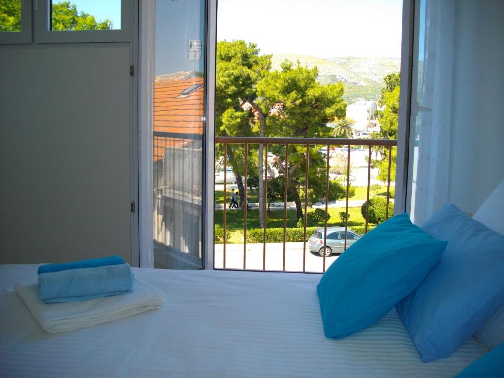 a bedroom with a bed with a view of a balcony at Studio Goga in Trogir