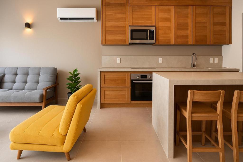 een keuken met een gele stoel en een bank bij Costta Loft L1 - Santa Cruz in Santa Cruz Huatulco