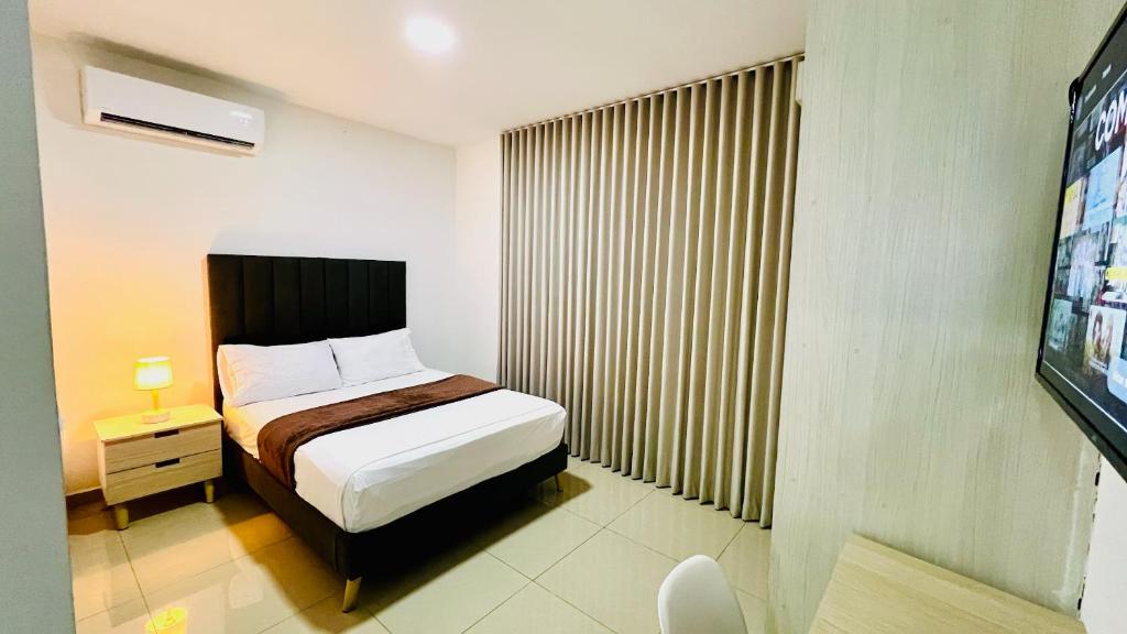a small bedroom with a bed and a tv at 405 studio apartment in El Peñon in Cali
