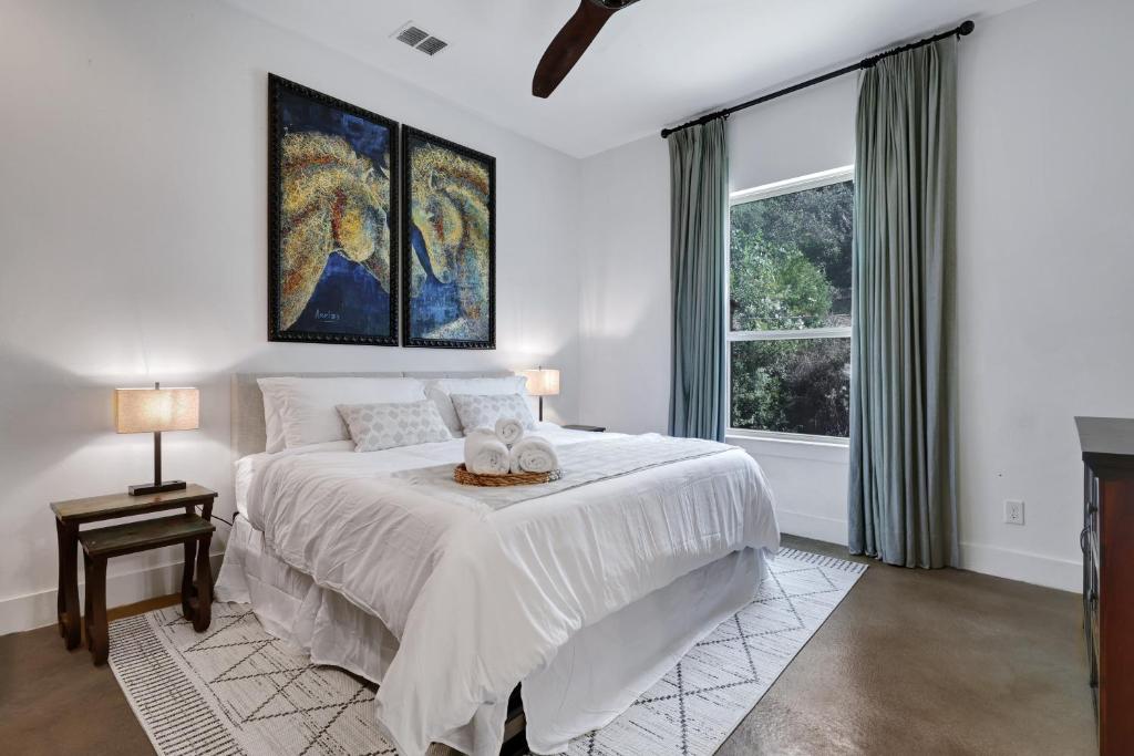 a white bedroom with a large bed and a window at Hacienda - A Birdy Vacation Rental in San Antonio