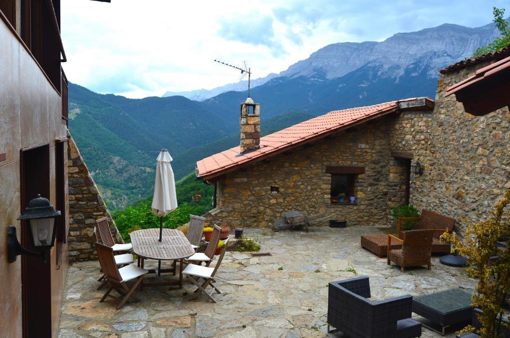 a patio with a table and chairs and a building at Casa Rural al Pirineu in Ansobell