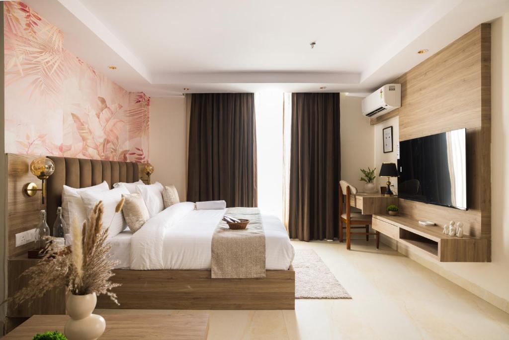 a bedroom with a large bed and a television at Lumi Stays- Luxurious Studio Apartment in Ghaziabad