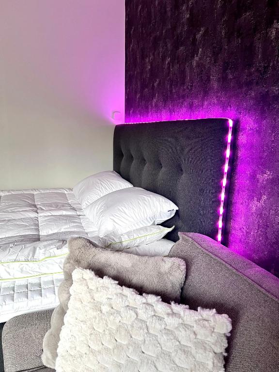 a bedroom with a bed with purple lights on it at Helmi Villa, keskellä Vuokatti Sauna Ilmainen Pysäköinti Wi-Fi in Vuokatti